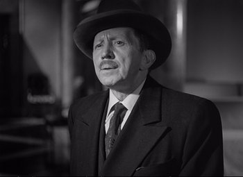 Movie still from “The Asphalt Jungle” (1950), directed by John Huston – An older man wearing a suit and a hat; Close Up shot, Low angle