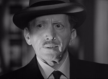 Movie still from “The Asphalt Jungle” (1950), directed by John Huston – An older man wearing a suit and a hat; Close Up shot, Low angle