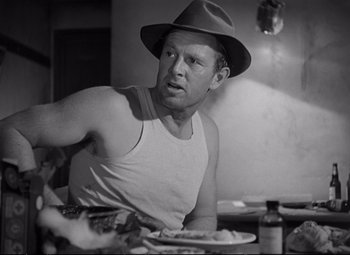 Movie still from “The Asphalt Jungle” (1950), directed by John Huston – A black and white photo of a man in a hat; Close Up shot, Over the shoulder angle