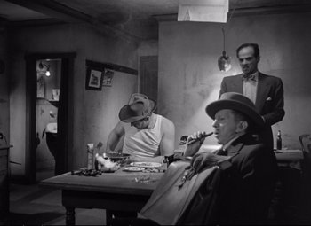Movie still from “The Asphalt Jungle” (1950), directed by John Huston – A group of men sitting around a table; Medium shot, Low angle