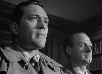 Movie still from “The Asphalt Jungle” (1950), directed by John Huston – A black - and - white photo of two men standing next to each other; Close Up shot, Low angle