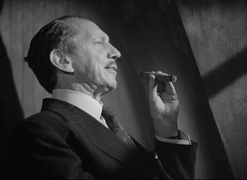 Movie still from “The Asphalt Jungle” (1950), directed by John Huston – An older man in a suit and tie holding a cigar; Medium shot, Low angle