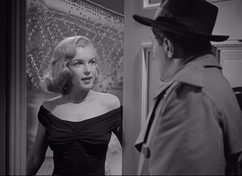 Movie still from “The Asphalt Jungle” (1950), directed by John Huston – A man and a woman are talking to each other; Medium shot, Over the shoulder angle