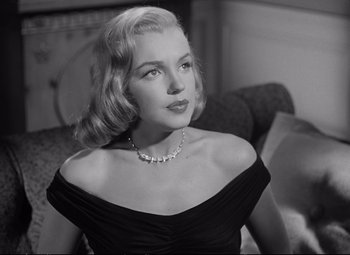 Movie still from “The Asphalt Jungle” (1950), directed by John Huston – A black and white photo of a woman in a black dress; Close Up shot, Low angle