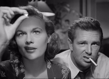 Movie still from “The Asphalt Jungle” (1950), directed by John Huston – An old black and white photo of a man and a woman smoking; Close Up shot, Low angle