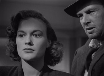 Movie still from “The Asphalt Jungle” (1950), directed by John Huston – A woman and a man standing next to each other in a room; Close Up shot, Low angle