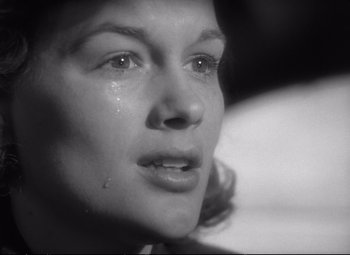 Movie still from “The Asphalt Jungle” (1950), directed by John Huston – A person with a tear in her eye; Close Up shot, Low angle