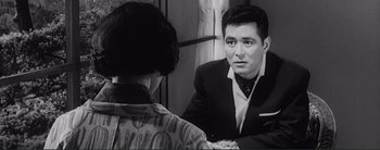 Movie still from “The Bad Sleep Well” (1960), directed by Akira Kurosawa – A black and white photo of a man and a woman in front of a mirror; Close Up shot, Over the shoulder angle