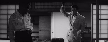 Movie still from “The Bad Sleep Well” (1960), directed by Akira Kurosawa – A black and white photo of a man in a bathrobe; Medium shot, Low angle