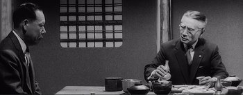 Movie still from “The Bad Sleep Well” (1960), directed by Akira Kurosawa – A man sitting at a table with a tea pot and cups; Medium shot, High angle