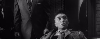 Movie still from “The Bad Sleep Well” (1960), directed by Akira Kurosawa – An old photo of a man getting his hair cut; Close Up shot, Low angle