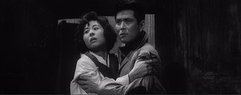 Movie still from “The Bad Sleep Well” (1960), directed by Akira Kurosawa – A man and a woman standing next to each other; Close Up shot, Low angle