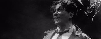 Movie still from “The Bad Sleep Well” (1960), directed by Akira Kurosawa – An old photo of a person with a funny face; Close Up shot, Low angle