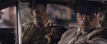 Movie still from “The Banker” (2020), directed by George Nolfi – A woman and a child in a car at night; Close Up shot, Over the shoulder angle
