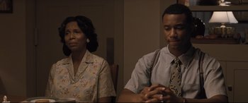 Movie still from “The Banker” (2020), directed by George Nolfi – A man and a woman sitting next to each other in a room; Medium shot, Over the shoulder angle