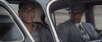 Movie still from “The Banker” (2020), directed by George Nolfi – A man and a boy in a car; Close Up shot, Over the shoulder angle