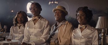 Movie still from “The Banker” (2020), directed by George Nolfi – A group of men sitting next to each other in a room; Medium shot, Low angle