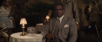 Movie still from “The Banker” (2020), directed by George Nolfi – A man sitting at a table in front of a woman; Medium shot, Over the shoulder angle