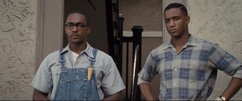 Movie still from “The Banker” (2020), directed by George Nolfi – A couple of men standing next to each other; Medium shot, Low angle