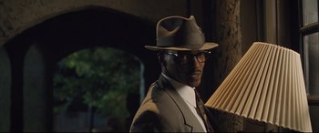 Movie still from “The Banker” (2020), directed by George Nolfi – A man in a suit and a hat; Medium shot, Low angle