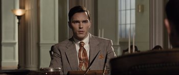 Movie still from “The Banker” (2020), directed by George Nolfi – A man wearing a suit and tie sitting at a table; Medium shot, Over the shoulder angle
