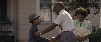Movie still from “The Banker” (2020), directed by George Nolfi – A man and a boy shaking hands while holding hands; Medium shot, Over the shoulder angle