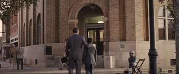 Movie still from “The Banker” (2020), directed by George Nolfi – A man and a boy walking down a sidewalk; Wide shot, Over the shoulder angle