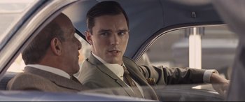Movie still from “The Banker” (2020), directed by George Nolfi – A man in a suit and tie sitting in the back of a car; Close Up shot, Over the shoulder angle