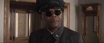 Movie still from “The Banker” (2020), directed by George Nolfi – A man wearing a black hat and sunglasses; Close Up shot, Low angle