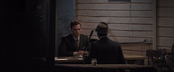 Movie still from “The Banker” (2020), directed by George Nolfi – Two men sitting at a table in front of each other; Medium shot, Over the shoulder angle