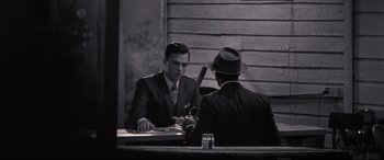Movie still from “The Banker” (2020), directed by George Nolfi – Two men sitting at a table in front of each other; Medium shot, Over the shoulder angle