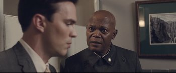 Movie still from “The Banker” (2020), directed by George Nolfi – A man looking at another man in the mirror; Close Up shot, Over the shoulder angle