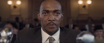 Movie still from “The Banker” (2020), directed by George Nolfi – A person wearing a suit and tie; Close Up shot, Low angle