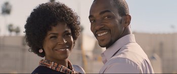 Movie still from “The Banker” (2020), directed by George Nolfi – A man and a woman smile for a picture; Close Up shot, Low angle