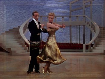 Movie still from “The Barkleys of Broadway” (1949), directed by Charles Walters – A man and a woman dancing on a stage in front of stairs; Wide shot, High angle