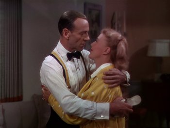 Movie still from “The Barkleys of Broadway” (1949), directed by Charles Walters – A man and a woman embracing each other in front of a couch; Medium shot, High angle