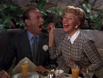 Movie still from “The Barkleys of Broadway” (1949), directed by Charles Walters – An older man and a younger woman are eating food together; Medium shot, High angle