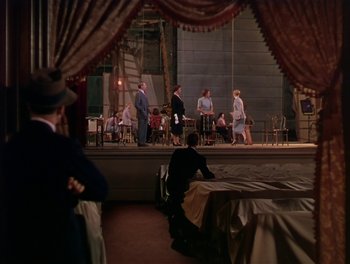 Movie still from “The Barkleys of Broadway” (1949), directed by Charles Walters – A group of people standing on a stage in front of a curtain; Extreme Wide shot, High angle