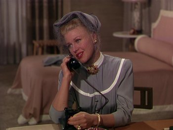 Movie still from “The Barkleys of Broadway” (1949), directed by Charles Walters – A woman sitting at a table talking on a phone; Medium shot, High angle