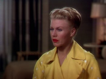 Movie still from “The Barkleys of Broadway” (1949), directed by Charles Walters – A woman in a yellow coat is sitting in a room; Close Up shot, Over the shoulder angle