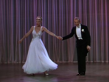 Movie still from “The Barkleys of Broadway” (1949), directed by Charles Walters – A man and a woman dressed in formal wear holding hands; Wide shot, Low angle