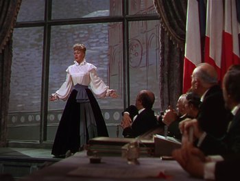 Movie still from “The Barkleys of Broadway” (1949), directed by Charles Walters – A woman standing in front of a group of people; Medium shot, Low angle