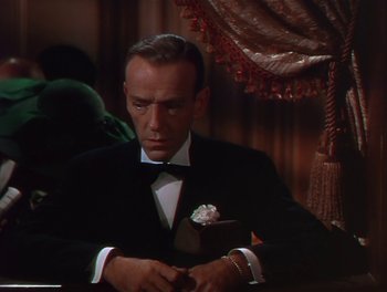 Movie still from “The Barkleys of Broadway” (1949), directed by Charles Walters – A man sitting at a dinner table wearing a tuxedo; Medium shot, High angle