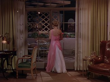 Movie still from “The Barkleys of Broadway” (1949), directed by Charles Walters – A woman in a pink dress looking out of a window; Wide shot, High angle