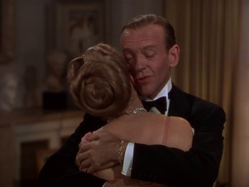 Movie still from “The Barkleys of Broadway” (1949), directed by Charles Walters – A man in a tuxedo hugging a woman in a black dress; Medium shot, High angle