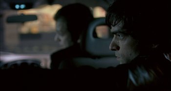 Movie still from “The Beat That My Heart Skipped” (2005), directed by Jacques Audiard – A man sitting next to another man in the back of a car; Close Up shot, Over the shoulder angle