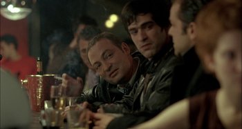 Movie still from “The Beat That My Heart Skipped” (2005), directed by Jacques Audiard – A group of men sitting at a table drinking and smoking; Close Up shot, Over the shoulder angle