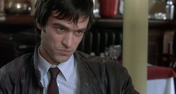 Movie still from “The Beat That My Heart Skipped” (2005), directed by Jacques Audiard – A person wearing a suit and tie; Close Up shot, Over the shoulder angle