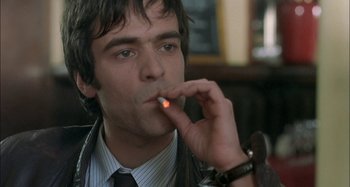 Movie still from “The Beat That My Heart Skipped” (2005), directed by Jacques Audiard – A man in a suit and tie smoking a cigarette; Close Up shot, Low angle