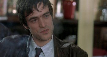 Movie still from “The Beat That My Heart Skipped” (2005), directed by Jacques Audiard – A person wearing a suit and tie; Close Up shot, Over the shoulder angle